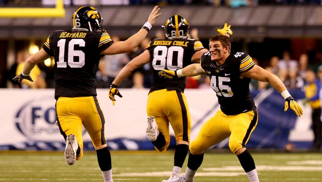 Iowa linebacker Eric Grimm (45) congratulates quarterback C.J. Beathard after throwing a long touchdown pass late in the fourth quarter against Michigan State during the Big Ten Championship Game at Lucas Oil Stadium on Dec. 5, 2015.