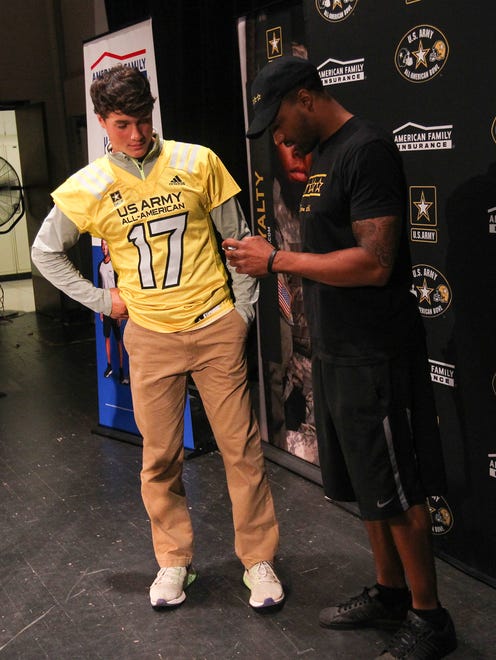 West High's Oliver Martin chats with former Hawkeye receiver Kevonte Martin-Manley after being presented with his U.S. Army All-American jersey at school on Thursday, Oct. 6, 2016.