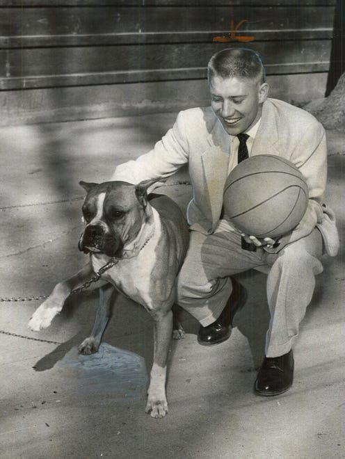 1957: Iowa State star Gary Thompson plays with a boxer owned by Des Moines restaurant owner Al "Babe" Bisignano, who drove Thompson to Kansas City where Thompson was named the Rockne Club's basketball player of the year.