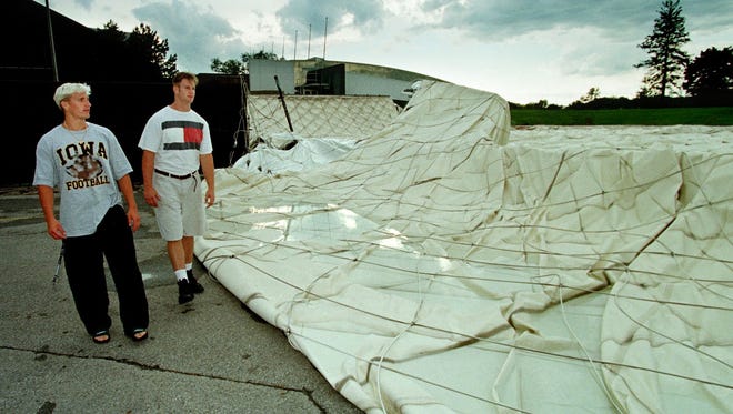 From 1998: University of Iowa football players Kevin Kasper, left, and Kyle Trippeer survey the collapsed inflatable roof of the team's indoor practice building in June 1998 in Iowa City.