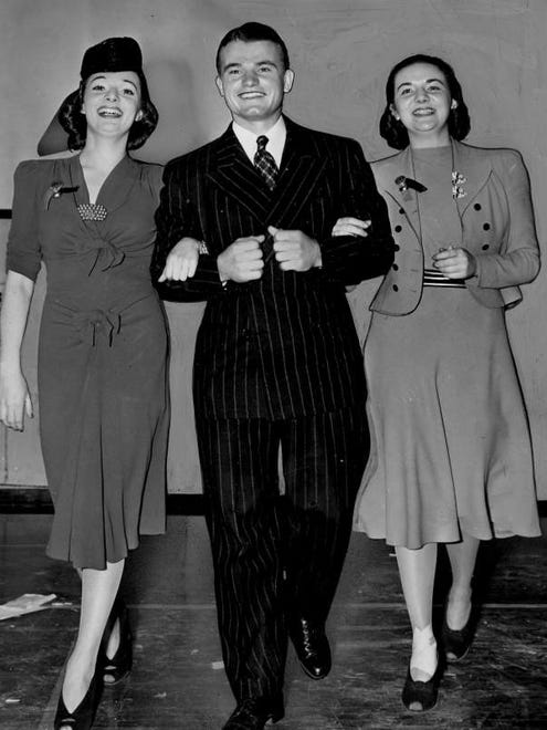 Dec. 6, 1939 - Nile Kinnick walks through the Downtown Athletic Club with fellow Iowans Mary Jane and Catherine Walsh, sisters from Davenport. Mary Jane (left) was currently the star of a Broadway play titled 'Too Many Girls'.