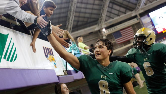 Iowa City West's Oliver Martin (8) and Devontae Lane (6) high five fans in the stands Friday, Nov. 11, 2016, after defeating Cedar Rapids Washington in their 4A state semifinal game at the UNI Dome in Cedar Falls.