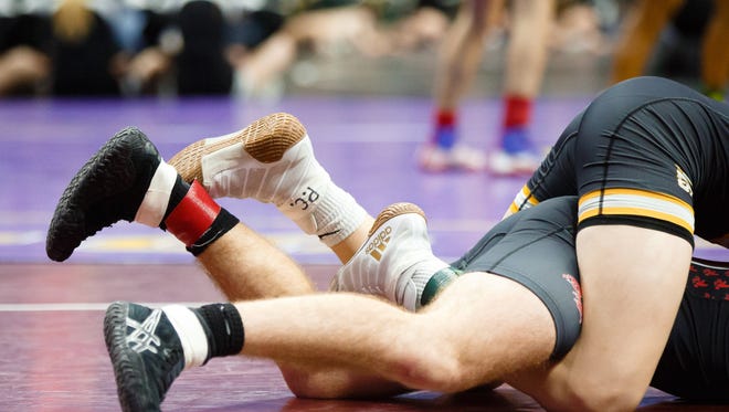 Lance Runyon of Southeast Polk wrestles Kyle Hefley of Iowa City, City High during their first round 3A state championship 152 lb match on Thursday, Feb. 15, 2018, in Des Moines. Runyon, who inscribes "P.C." onto his shoes, would go on to win by a 9-0 major decision.