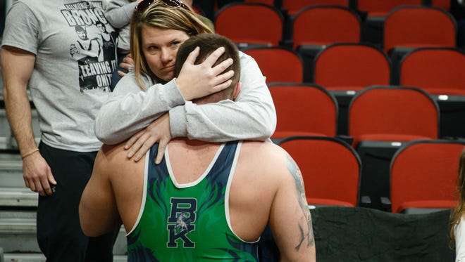 After loosing to Jesup's Brian Sadler by pin, Cameron Beminio gets consoled by family members following his 1A semi-final round at the state wrestling championships on Friday, Feb. 16, 2018, in Des Moines.