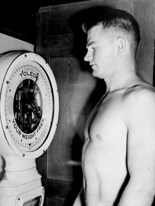 Undated photo - Nile Kinnick weighs in at the Iowa Fieldhouse inching near the 170-pound weight goal he had set for himself.
