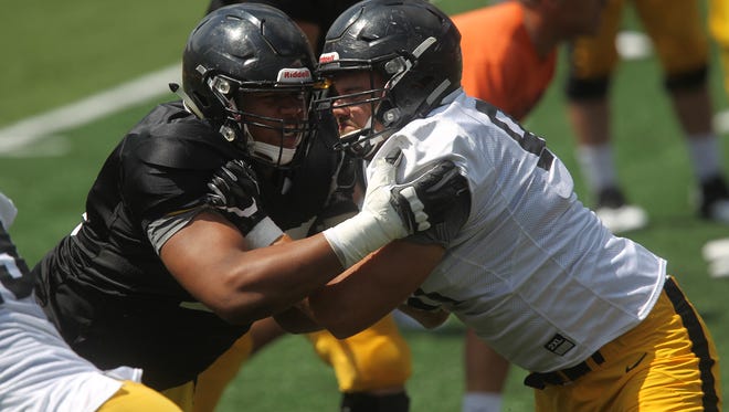 Iowa offensive lineman Alaric Jackson, left, sets up a block against defensive end Sam Brincks during the open practice on Kids Day at Kinnick Stadium on Saturday, Aug. 12, 2017.