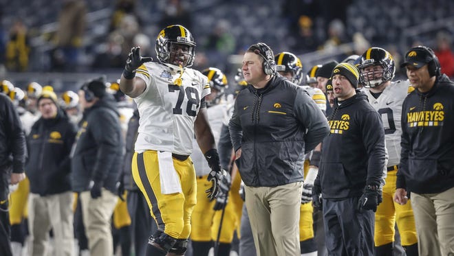 Iowa junior center James Daniels discusses with offensive coordinator Brian Ferentz on the sideline against Boston College during the 2017 Pinstripe Bowl at Yankee Stadium in Bronx, New York on Wednesday, Dec. 27, 2017.
