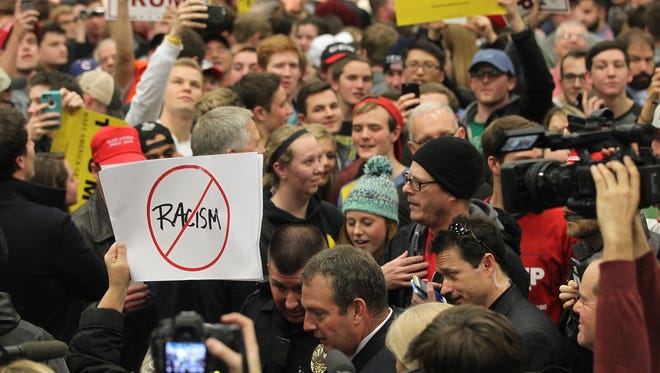 A protestor is escorted out of the building prior to the appearance of Republican presidential candidate Donald Trump at the University of Iowa Field House in Iowa City on Tuesday, Jan. 26, 2016.