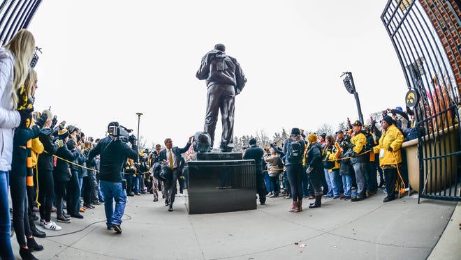 Iowa coach Kirk Ferentz is surrounded by fans as he arrives before the team's game against Nebraska at Kinnick Stadium.