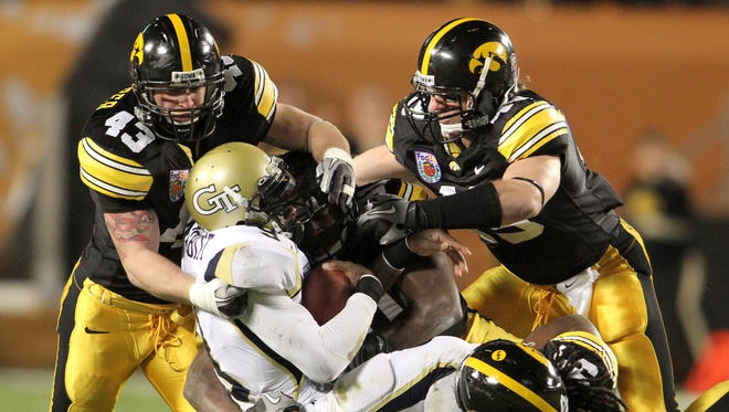 Georgia Tech quarterback Josh Nesbitt is gang tacked by Iowa linebacker Pat Angerer, top, defensive tackle Broderick Binns, linebacker A.J. Edds and defensive tackle Adrian Clayborn in the first quarter Tuesday at the 2010 Orange Bowl at Land Shark  Stadium in Miami Gardens.