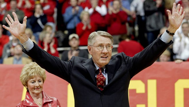 Iowa State's long time TV announcer Gary Thompson holds up his arms as he acknowledges the cheer of the crowd during 2005 half-time ceremony. Behind him is his wife, Janet.