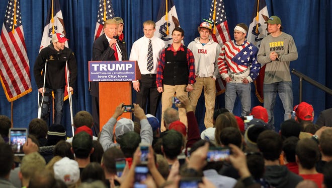 Republican presidential candidate Donald Trump greets members of Iowa's wrestling team at the University of Iowa Field House in Iowa City at 8:31 p.m. Tuesday, Jan. 26, 2016.