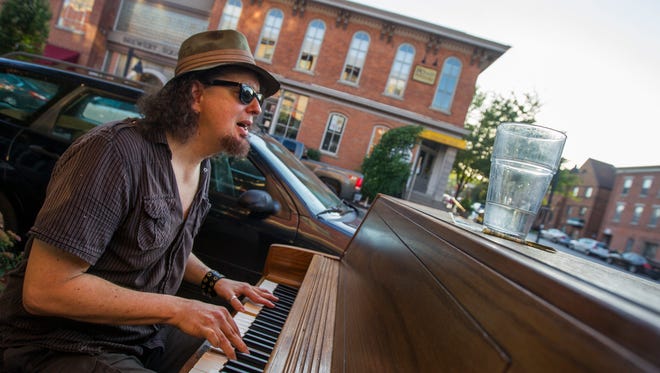 Brandon Ross, of Iowa City, performs along Linn Street during in downtown Iowa City on Friday, June 29, 2018. Ross is a guitarist and composer originally from Boston, Massachusetts.