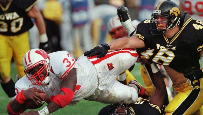 From 1998: Wisconsin running back Ron Dayne dives for extra yards against Iowa defenders Ryan Loftin (48) and Eric Thigpen.