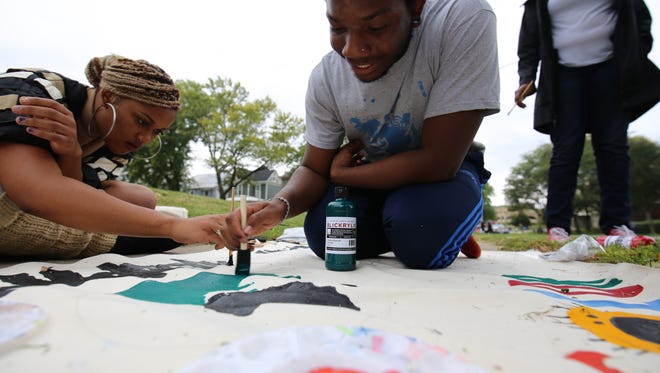 Brooke Kimberough, left, and David Mayes-Butler paint the sign for Black Student Union parade float Friday, Sept. 30, 2016, in Iowa City.