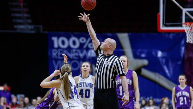 A game official puts the ball into play as Newell-Fonda and Kee High start their game during the 2018 Iowa Class 1A girls state basketball quarterfinal game on Tuesday, Feb. 28, 2018, at Wells Fargo Arena in Des Moines