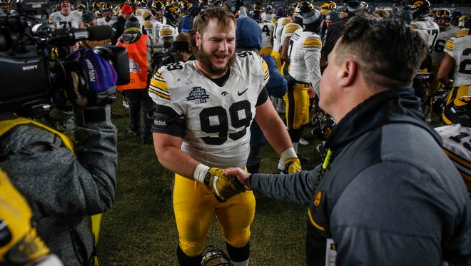 Iowa senior tackle Nathan Bazata gets a handshake from offensive coordinator Brian Ferentz after the Hawkeyes won, 27-20, over Boston College during the 2017 Pinstripe Bowl at Yankee Stadium in Bronx, New York on Wednesday, Dec. 27, 2017.