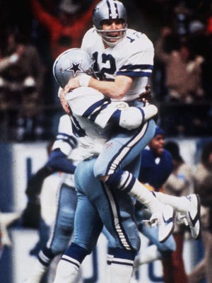 Roger Staubach (12) celebrating after throwing a touchdown pass in a 1975 game, threw his famed Hail Mary pass in the playoffs that season to lift the Cowboys over the Vikings.