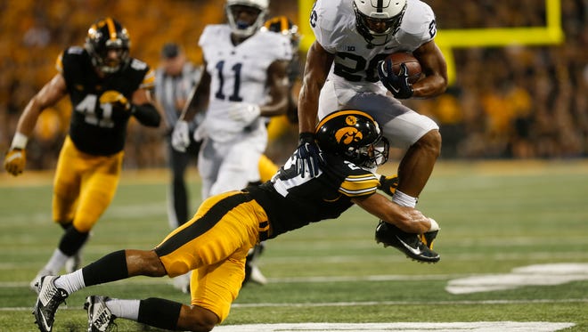 Iowa's Amani Hooker tackles Penn State's Saquon Barkley during their game at Kinnick Stadium on Saturday, Sept. 23, 2017.