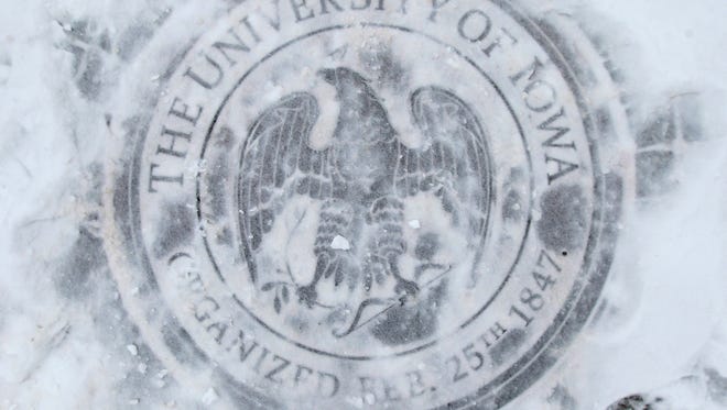 Snow covers the University of Iowa's crest on Clinton Street on Monday, Feb. 5, 2018.