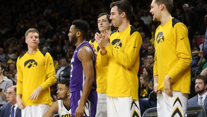 Northwestern's Isiah Brown, surrounded by Iowa's bench, reacts to a call during the Wildcats' game at Carver-Hawkeye Arena on Sunday, Feb. 25, 2018.