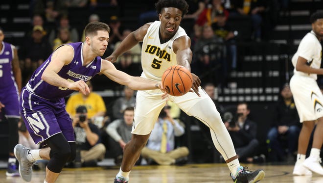 Northwestern's Bryant McIntosh and Iowa's Tyler Cook fight for the ball during their game at Carver-Hawkeye Arena on Sunday, Feb. 25, 2018.