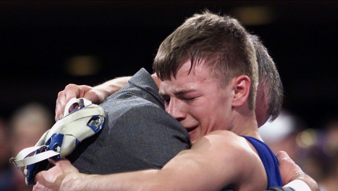 Jesse Sundell of Ogden hugs his coach after winning Class 1A 119-pound state title, the fourth of his career at the state wrestling championships.