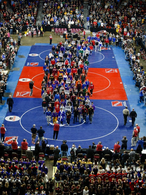 Wrestlers enter at Wells Fargo Arena in the Grand March before the state wrestling championships on Saturday, Feb. 17, 2018, in Des Moines.