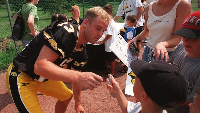 From 1998: Iowa quarterback Randy Reiners was the object of autograph seekers during Hawkeyes football fan/media day in Iowa City. Here he returns a pen to Garrett Knock, 7, of Cedar Rapids after signing the boy's shirt.