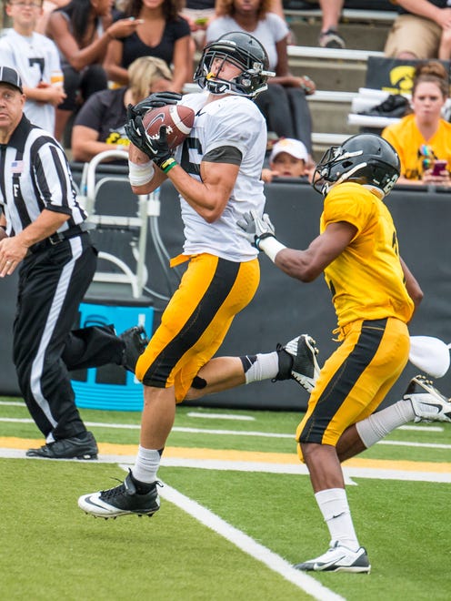 George Kittle (46) catches the ball as Malik Rucker (2) chases during the practice session at Kinnick Stadium in Iowa City for Kids Day with the Iowa Football team on Saturday August 16, 2014. The day featured stadium tours, autograph signing, and a scrimage practice by the Hawkeyes as they prepare to open the 2014-2015 season against UNI on August 30th.