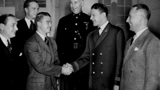 Dec. 7, 1939 - Nile Kinnick shakes hands with Navy football captain Allen Bergner at a luncheon in New York before the Heisman Trophy ceremony.