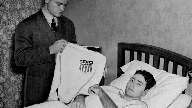 Dec. 10, 1939 - Nile Kinnick presents his all-America sweater to Edwin "Rip" Collins, a New Jersey prep school player from New Jersey who had his leg amputated after an in-game injury. Collins had his leg amputated three days earlier.