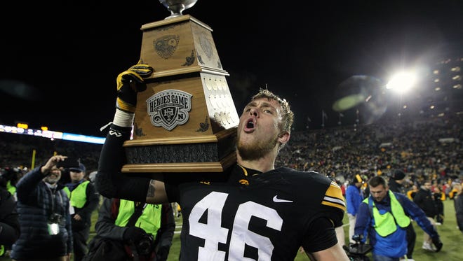 Iowa senior George Kittle celebrates with the Heroes Trophy after beating Nebraska, 40-10. Kittle had two short TD receptions in the game despite playing through a mid-foot sprain that limited him in the second half of the football season.