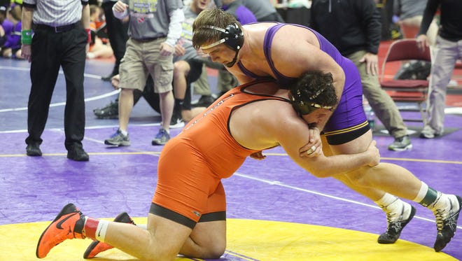 Indianola senior 285-pounder Eagan Lickiss (in purple) wrestles Waterloo East senior Omar Begic in a first-round match Feb. 15 at the Class 3A state tournament at Wells Fargo Arena in Des Moines.