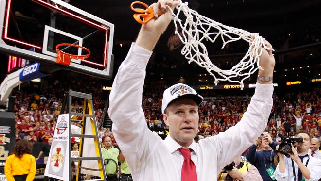 Iowa State Head coach Fred Hoiberg raises the net after cutting it from the rim following the Cyclones' win over Baylor to secure the Big 12 tournament championship on March 15, 2014, in Kansas City, Mo.