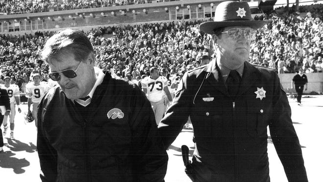 From 1989: Iowa Hawkeyes football coach Hayden Fry is escorted off the field by Ron Stewart.