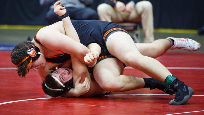 Tyler Linderbaum of Solon, top pins West Delaware, Manchester's Carson Petlon during their first round 2A 285lb match on Thursday, Feb. 15, 2018, in Des Moines.