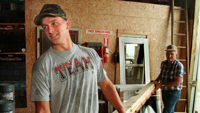 From 1998: Aplington-Parkersburg's Aaron Kampman, front, and his grandfather Claas Kampman, stacks boards at the family's lumberyard in Kesley. Aaron Kampman was the Register's 1998 male athlete of the year before going on to star at Iowa and the NFL.