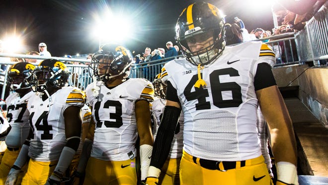 Iowa's George Kittle (46) and Greg Mabin (13) get set to come out of the Beaver Stadium tunnel on Nov. 5. That was the last time either has played for the Hawkeyes; on Tuesday, each discussed their injury situation.