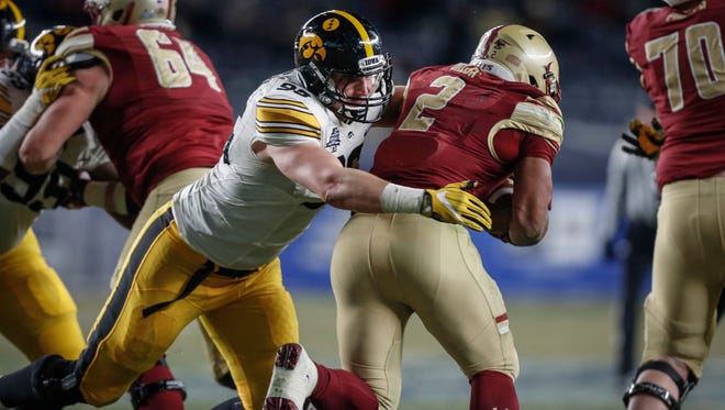 Iowa left tackle Matt Nelson tackles Boston College running back AJ Dillon during the 2017 Pinstripe Bowl at Yankee Stadium in Bronx, New York on Wednesday, Dec. 27, 2017.