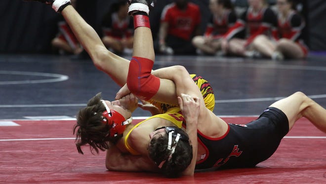 Carlisle sophomore 113-pounder Carter Logue (in yellow) wrestles Cedar Falls sophomore Jakey Penrith in a Class 3A opening-round match at the state wrestling meet Feb. 16 at Wells Fargo Arena in Des Moines.