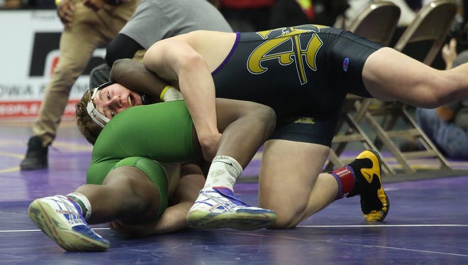 Norwalk junior 220-pounder Drake Leek (in black) wrestles Iowa City West junior Guy Snow in a Class 3A opening-round match at the state wrestling meet Feb. 16 at Wells Fargo Arena in Des Moines.