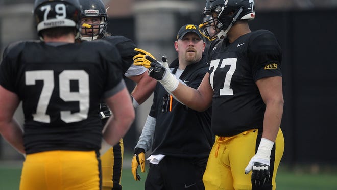 Iowa offensive line coach Tim Polasek gives a pointer to redshirt freshman tackle Alaric Jackson at a practice  last week.