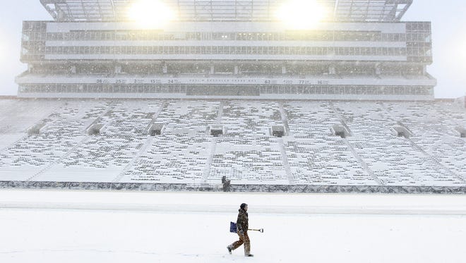 Workers clear snow off Kinnick Stadium's field on Saturday, Nov. 21, 2015.