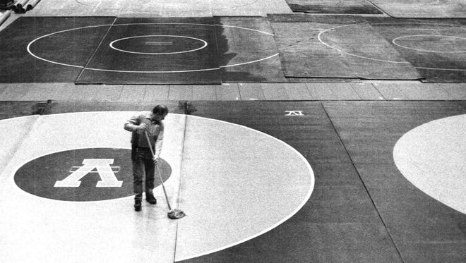 From 1992: Daryl Nerness cleans the mats between state wrestling sessions at Veterans Memorial Auditorium.