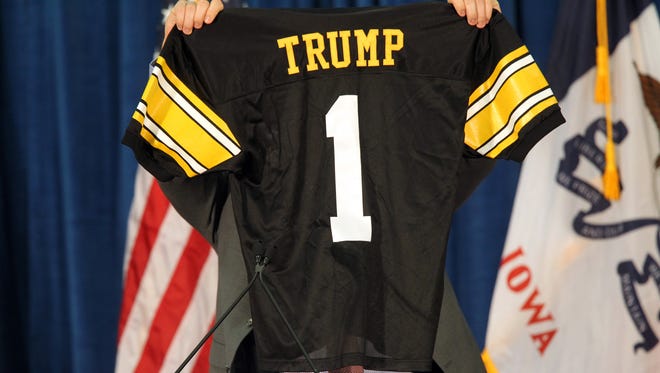 Iowa tight end Peter Pekar holds up a personalized jersey prior to the appearance of Republican presidential candidate Donald Trump at the University of Iowa Field House in Iowa City on Tuesday, Jan. 26, 2016.