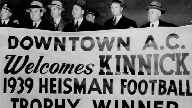Nile Kinnick, third from right, stands behind a welcome sign waiting for him at Floyd Bennett airport when he arrived Dec. 7, 1939 in New York for the Heisman Trophy ceremony. Second from right is Iowa coach Eddie Anderson.