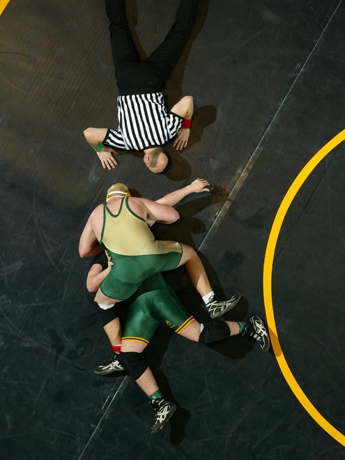 From 2005: Travis Meade of Iowa City West, back to camera, pins Cory Tuegel of Dubuque Hempstead in the first round of the Class 3A tournament at 275 pounds at Veterans Memorial Stadium.