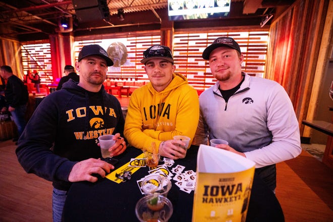 Darren Kriz, Alex Caba and Dommonick Pechous of South Dakota, attend the Hawkeye Huddle ahead of the NCAA championship semi final round Friday, March 22, 2024, at the Power and Light District in Kansas City, Missouri.