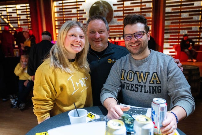Lance and Anna Forbes and Ryan Shellady of Iowa City attend the Hawkeye Huddle ahead of the NCAA championship semi final round Friday, March 22, 2024, at the Power and Light District in Kansas City, MO.